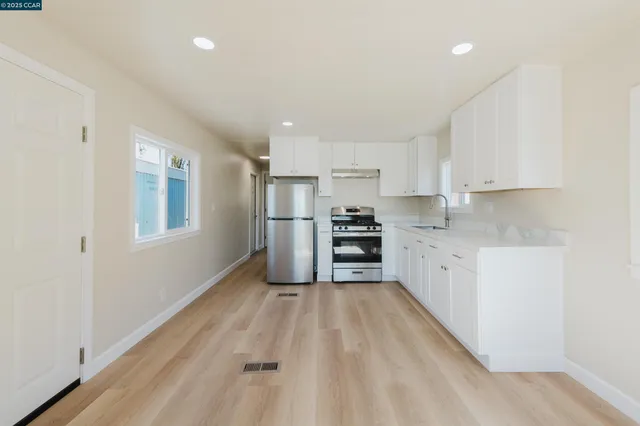 a kitchen with granite countertop white cabinets and stainless steel appliances