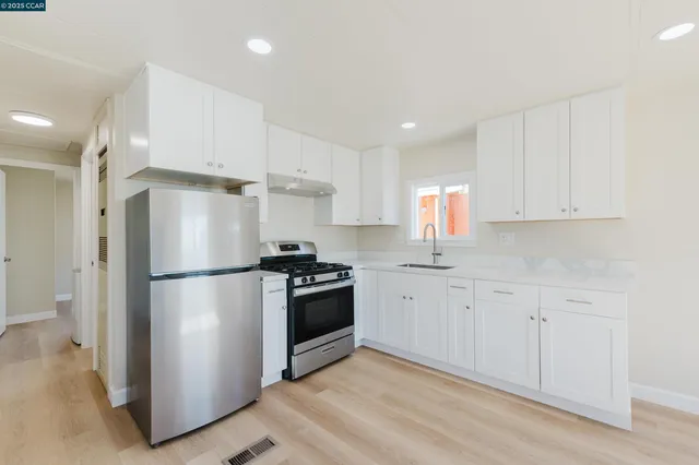 a kitchen with white cabinets and stainless steel appliances