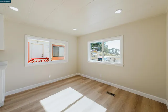an empty room with wooden floor and window