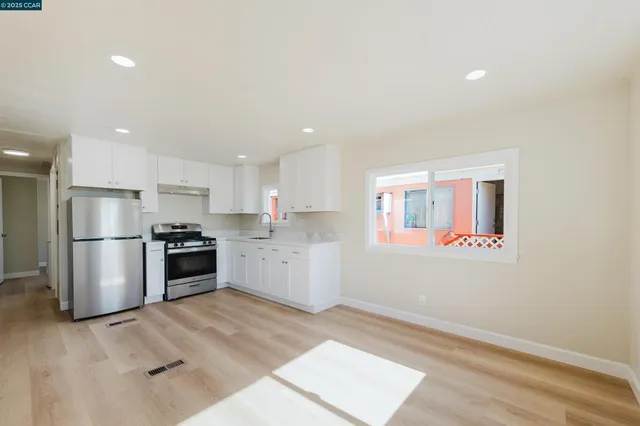 a kitchen with a refrigerator and a stove top oven