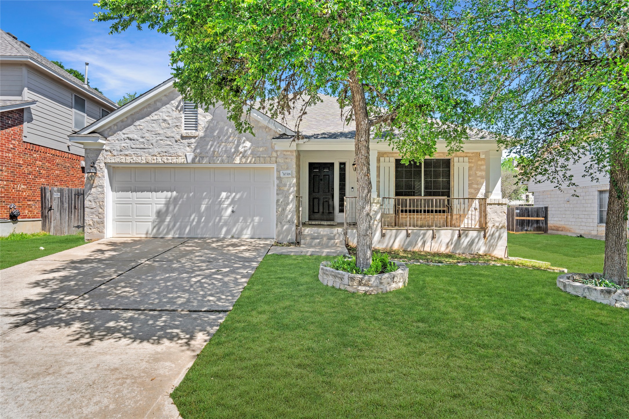 10318 Broomflower Drive Austin, TX 78739 - Photo 1 of 1 a front view of a house with a garden and yard