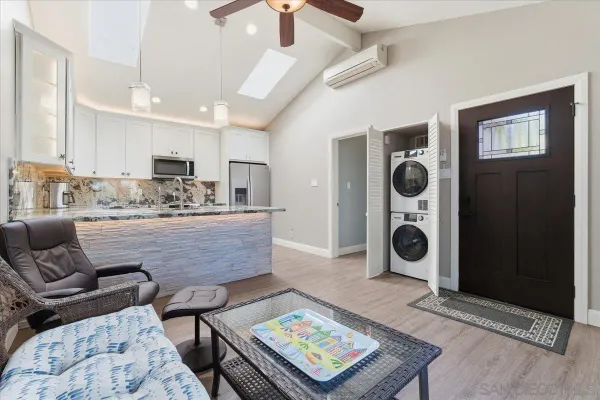 a living room with furniture and view of kitchen
