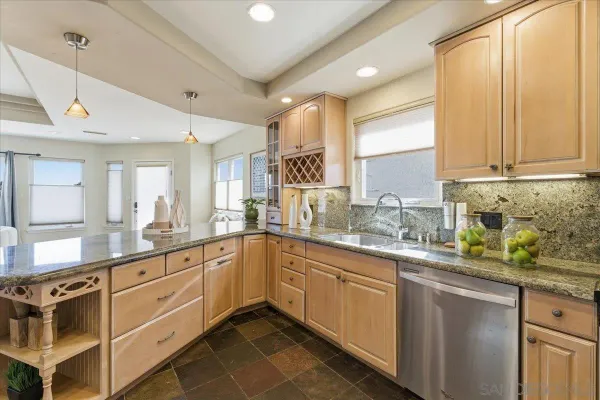 a kitchen with granite countertop white cabinets and stainless steel appliances