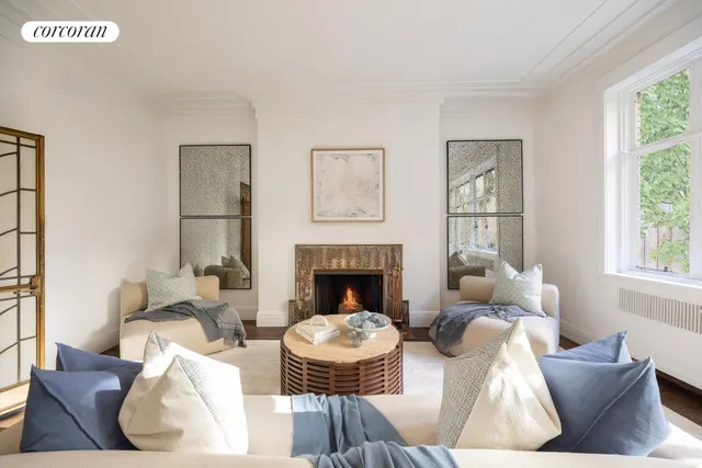 a living room with fireplace furniture and a large window