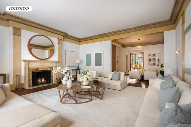 a living room with furniture a large window and a fireplace