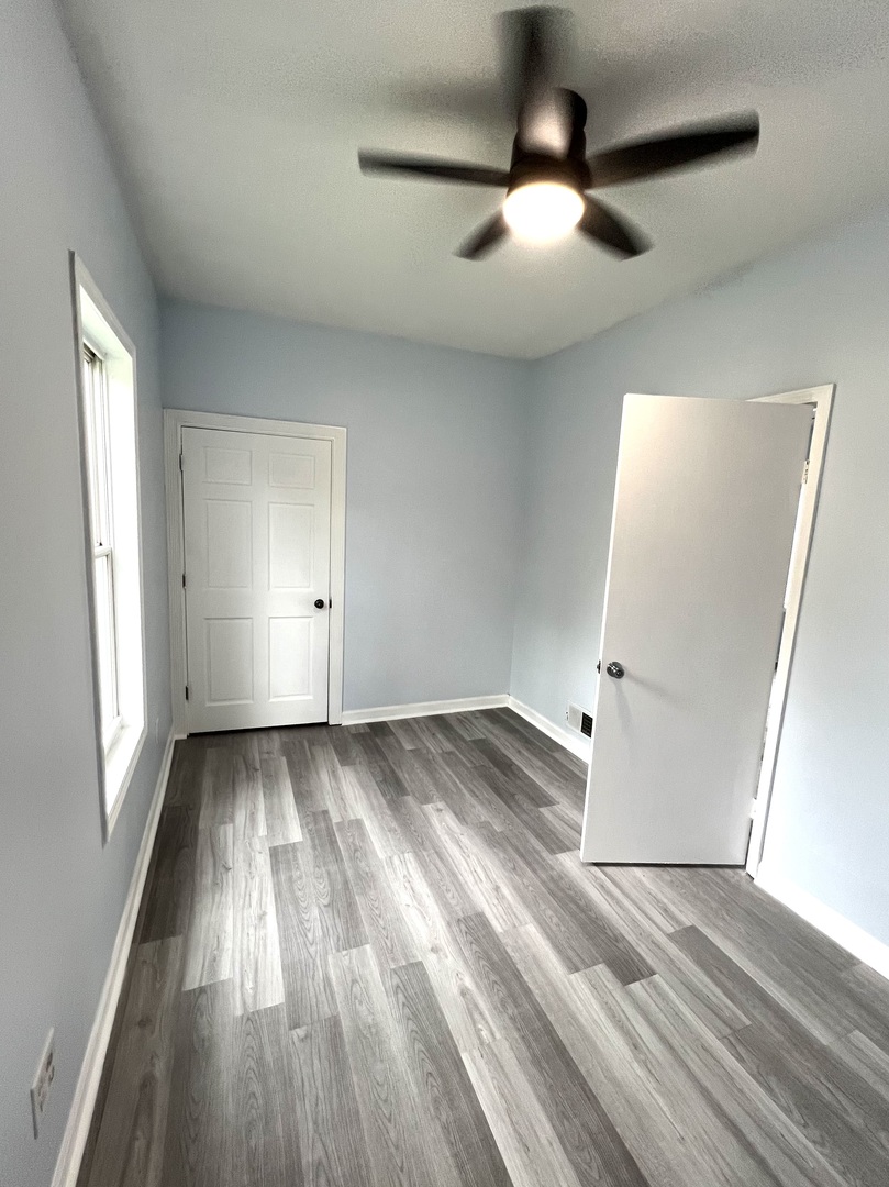 3002 Green Street, Unit 1 Steger, IL 60475 - Photo 18 of 29 wooden floor in an empty room with a window