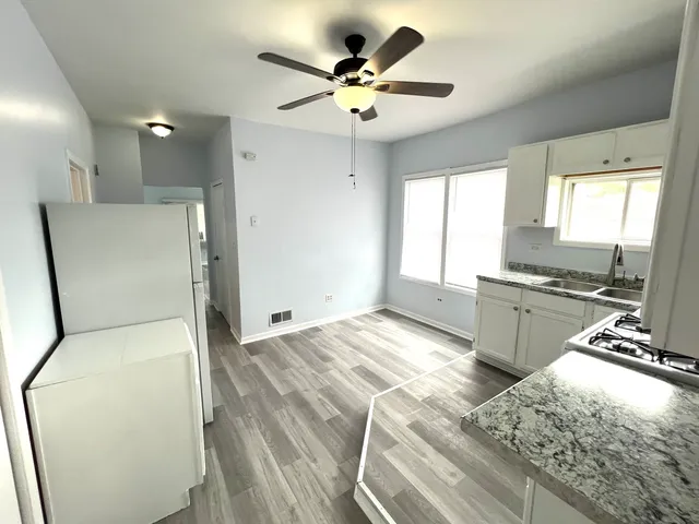 a view of a kitchen with cabinets stainless steel appliances and a large window
