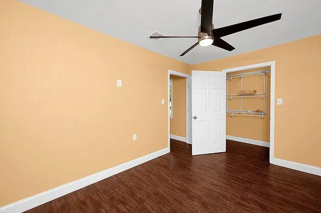 a view of an empty room with wooden floor