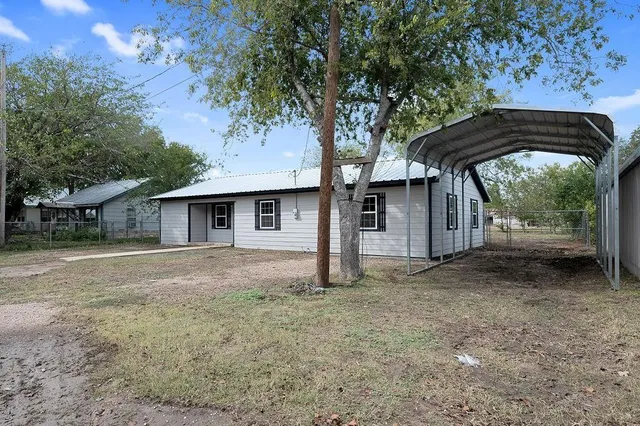 a view of a house with backyard and trees