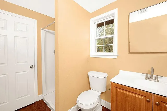 a bathroom with a toilet a sink and a window