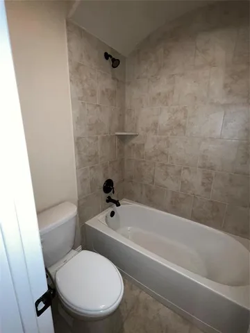 a white toilet and tub sitting next to a bathroom sink
