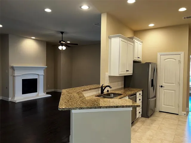 a kitchen with granite countertop a refrigerator and a stove