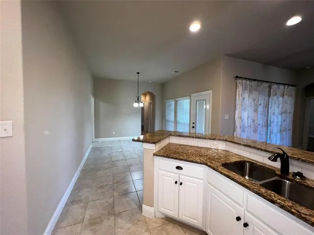 a kitchen with granite countertop a sink and cabinets