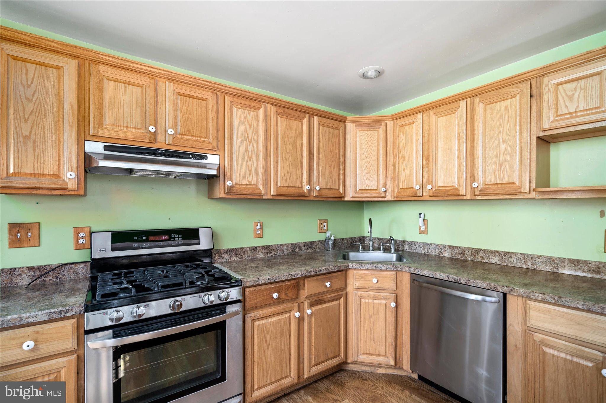 41 Collins Road Hamilton, NJ 08619 - Photo 9 of 23 a kitchen with stainless steel appliances granite countertop a stove a sink and dishwasher with wooden cabinets