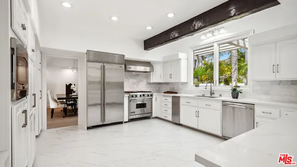 a kitchen with stainless steel appliances a refrigerator sink and cabinets