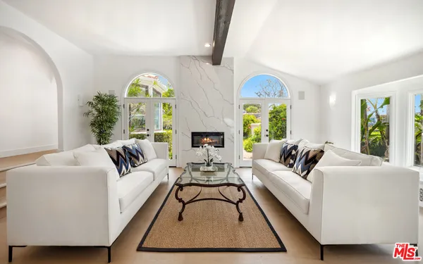 a living room with furniture fireplace and a large window