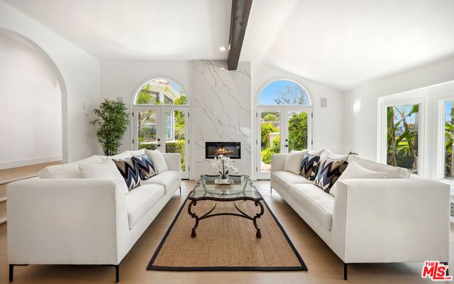 a living room with furniture fireplace and a large window