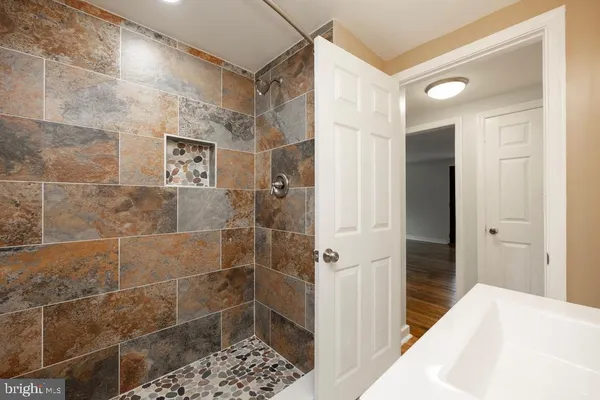 a bathroom with a sink a toilet and shower