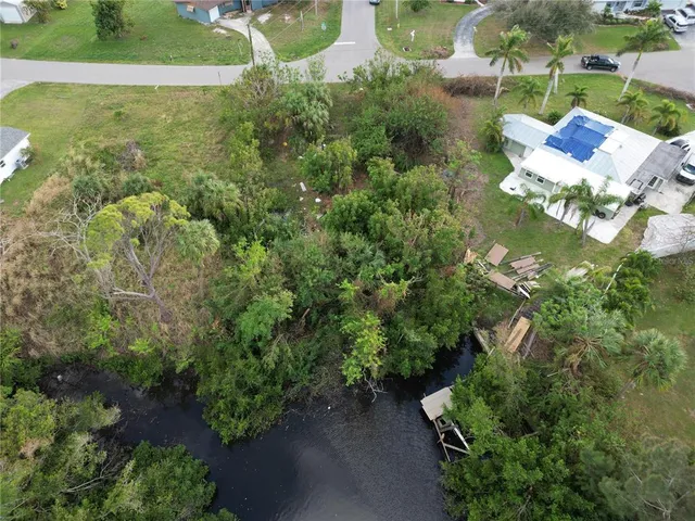 an aerial view of a house with a yard and lake view
