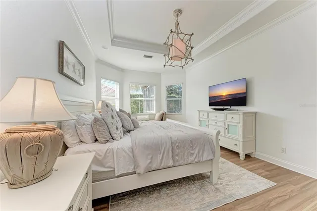 a spacious bedroom with a bed and a flat screen tv