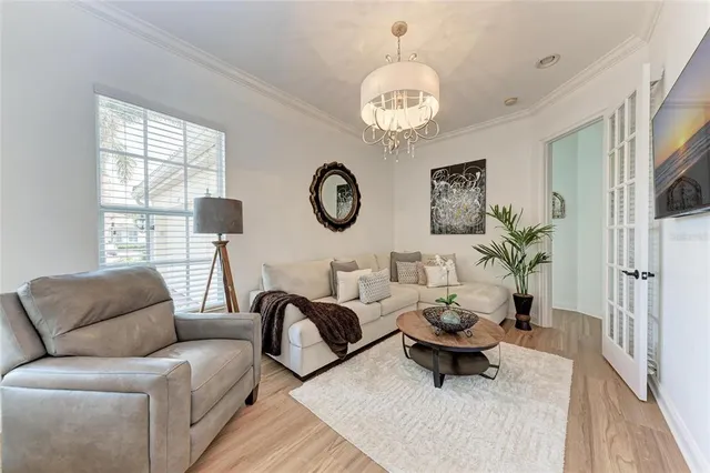 a living room with furniture a chandelier and a large window