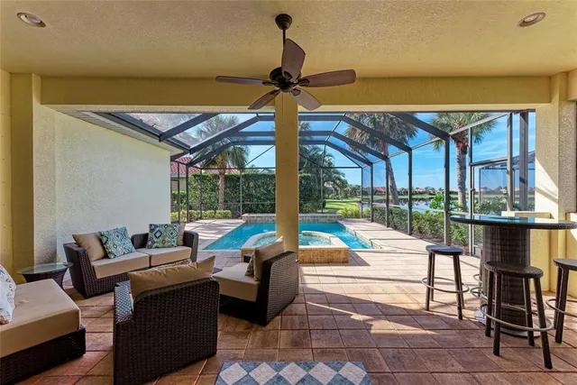 a living room with patio furniture and a floor to ceiling window