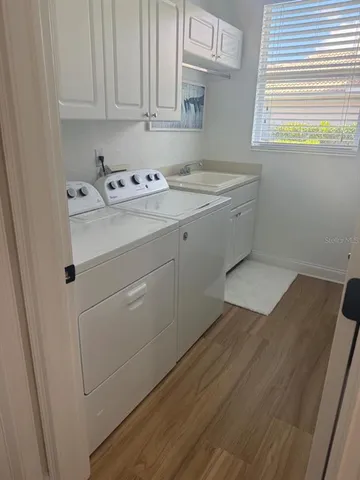 a utility room with cabinets washer and dryer