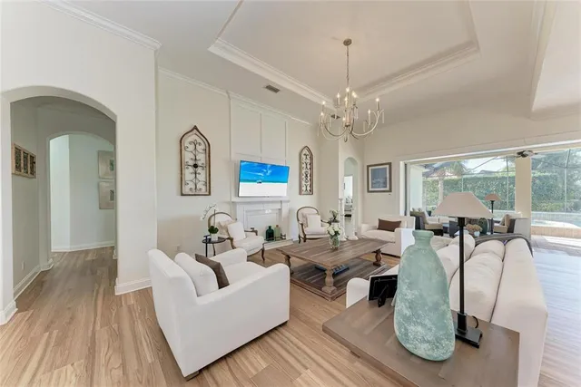 a living room with furniture a large window and potted plants