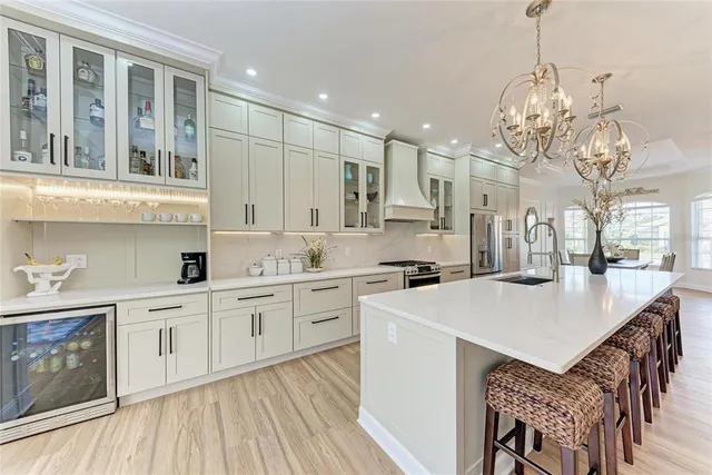 a open kitchen with stainless steel appliances granite countertop a sink dishwasher and white cabinets with wooden floor