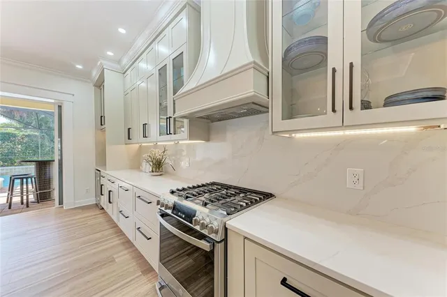 a kitchen with stainless steel appliances a stove a sink and a refrigerator with wooden floor