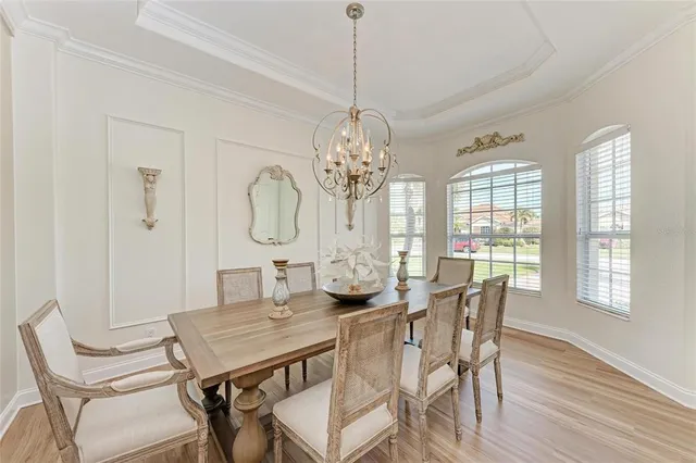 a view of a dining room with furniture a chandelier and wooden floor