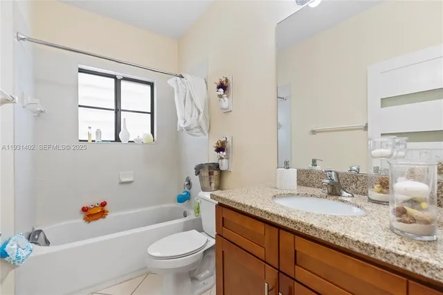 a bathroom with a granite countertop toilet sink and mirror