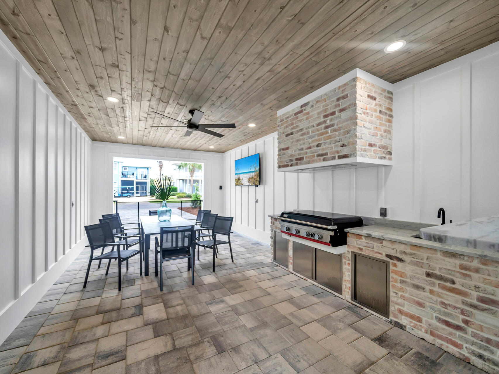 84 Mark Street Destin, FL 32541 - Photo 52 of 81 a kitchen with stainless steel appliances granite countertop a stove a sink dishwasher a dining table and chairs with wooden floor