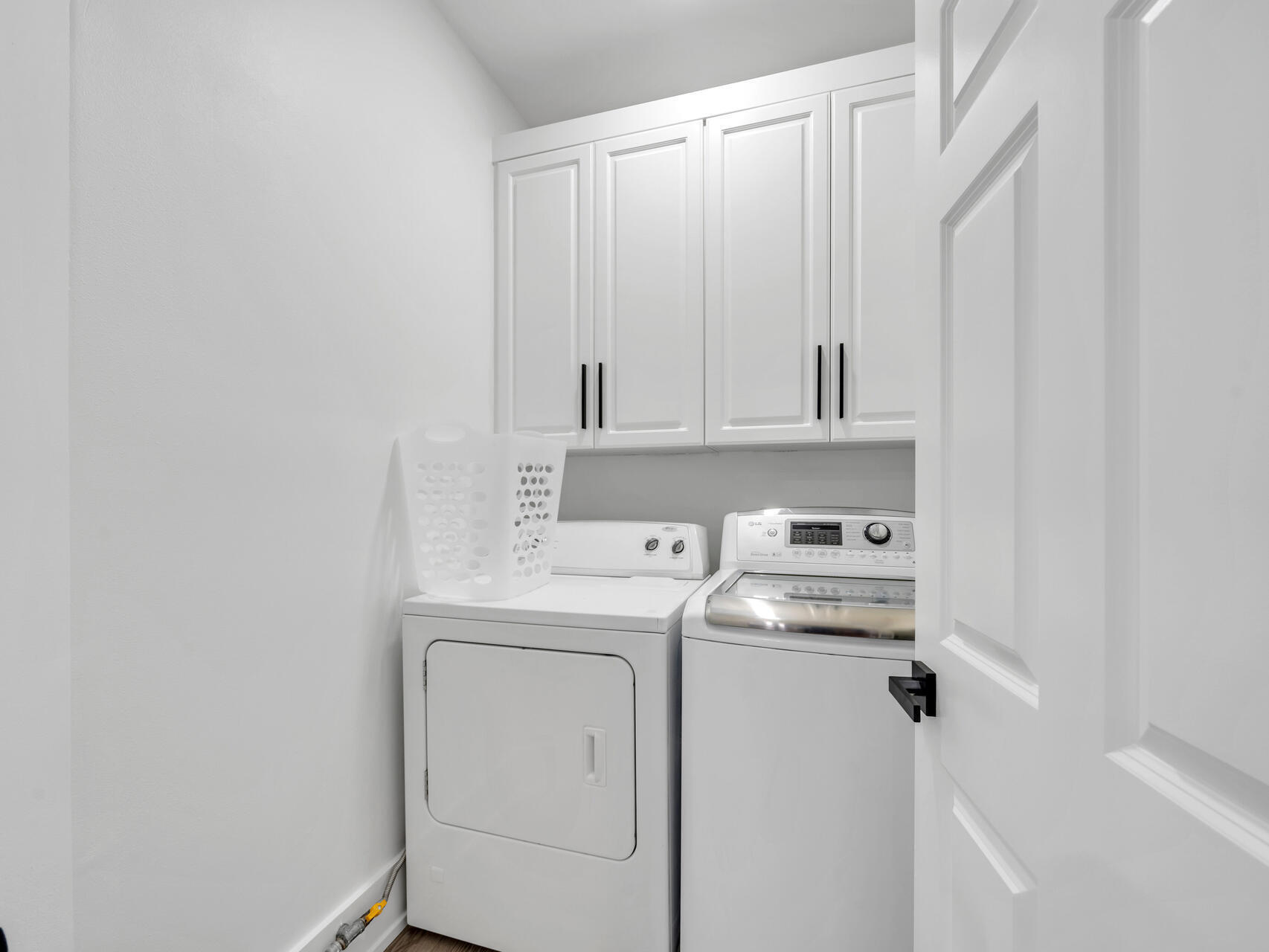 84 Mark Street Destin, FL 32541 - Photo 68 of 81 a view of washer and dryer with kitchen in the background