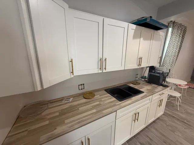 a kitchen with granite countertop white cabinets and white appliances