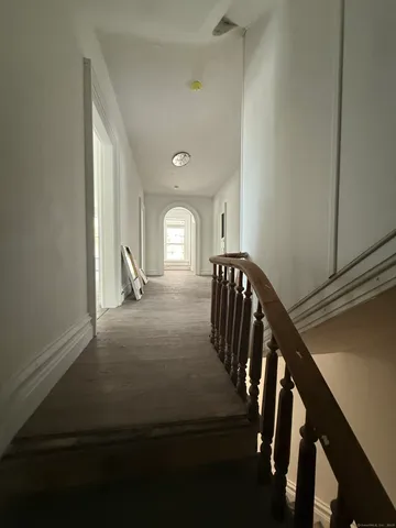an empty room with wooden floor and natural light
