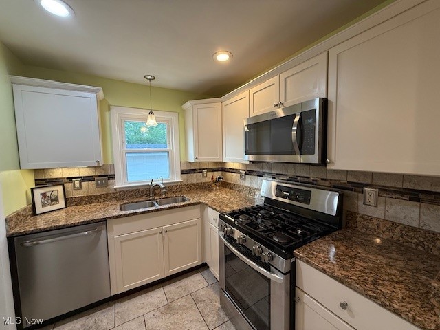 30101 Oakdale Road Willowick, OH 44095 - Photo 5 of 17 Kitchen with appliances with stainless steel finishes, a sink, white cabinetry, decorative backsplash, and dark stone countertops