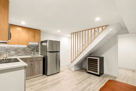 a kitchen with stainless steel appliances granite countertop a refrigerator and a stove top oven