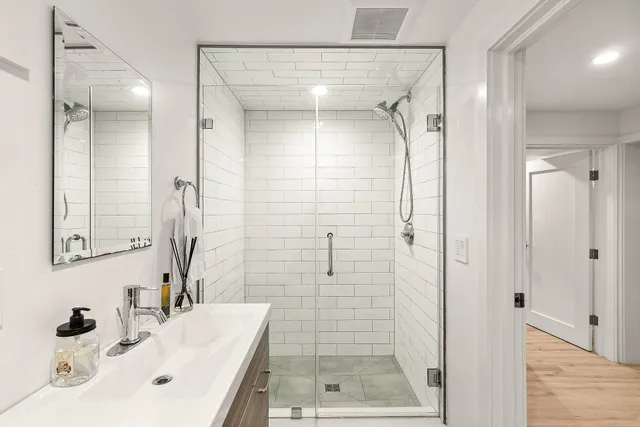 a bathroom with a shower sink and mirror