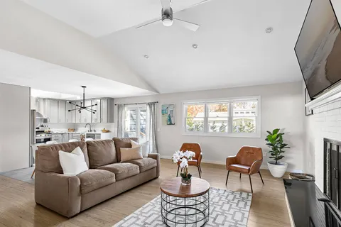 a living room with furniture a large window and a flat screen tv