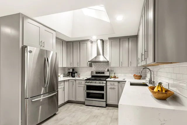 a kitchen with stainless steel appliances granite countertop a refrigerator a sink and a stove