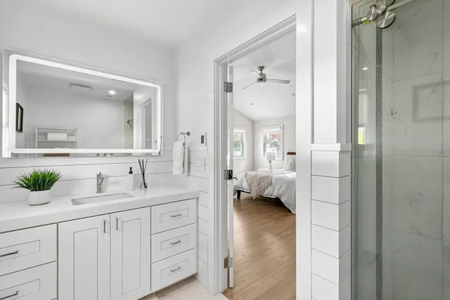 a en suite bathroom with a granite countertop sink and mirror