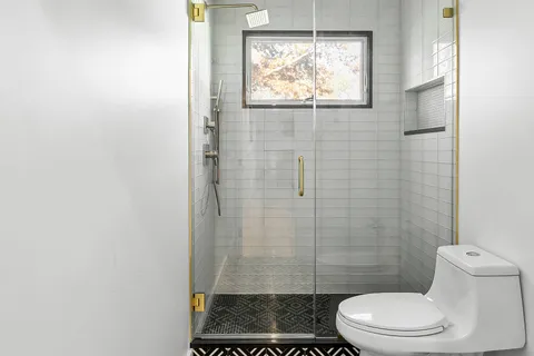 a bathroom with a toilet and a shower