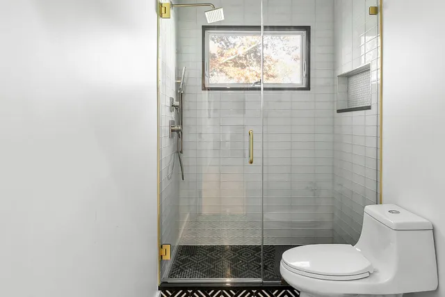 a bathroom with a toilet and a shower