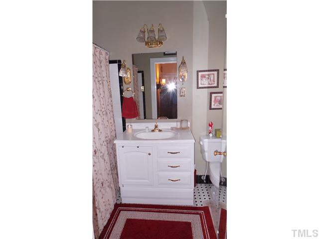 101 Forest Road Oxford, NC 27565 - Photo 11 of 25 The vanity in the Master Bath is shown here. Note the nice lighting fixtures above and beside the mirror. The mirror is reflecting the flash from the camera.