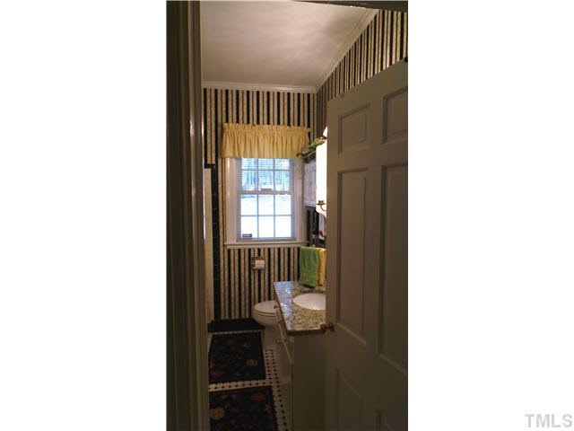 101 Forest Road Oxford, NC 27565 - Photo 12 of 25 The hallway bathroom is shown here. The vanity has a granite countertop. The floors and bath has black and white ceramic tile.