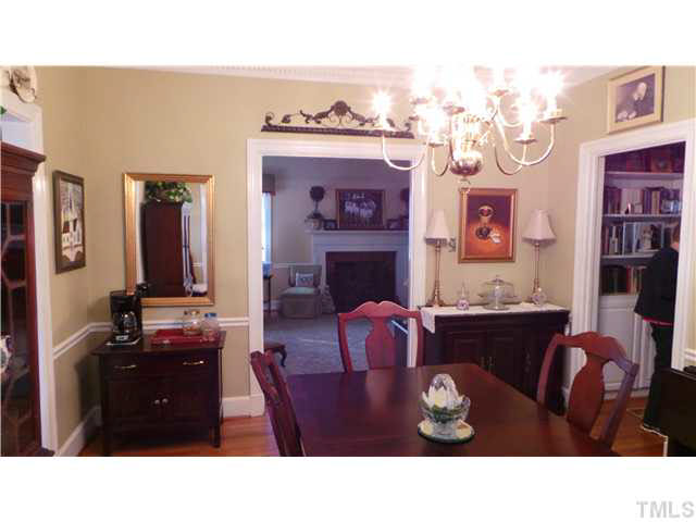 This views the Dining Room from the Sun Room door looking back toward the Living Room opening.  To the right you can see the built-in book shelves in the hallway.  The Kitchen is the left doorway.