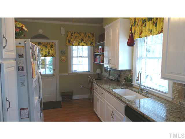 From the opposite end of the Kitchen,  This shows the back door and the sit-down breakfast area at the right end of the counter.  Note how light and bright the Kitchen is.  All windows on this level of the house have double-hung replacement windows.