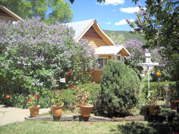 a view of a house with a yard and sitting area
