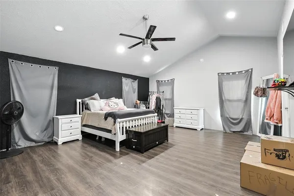 a bedroom with a bed a flat screen tv and dresser